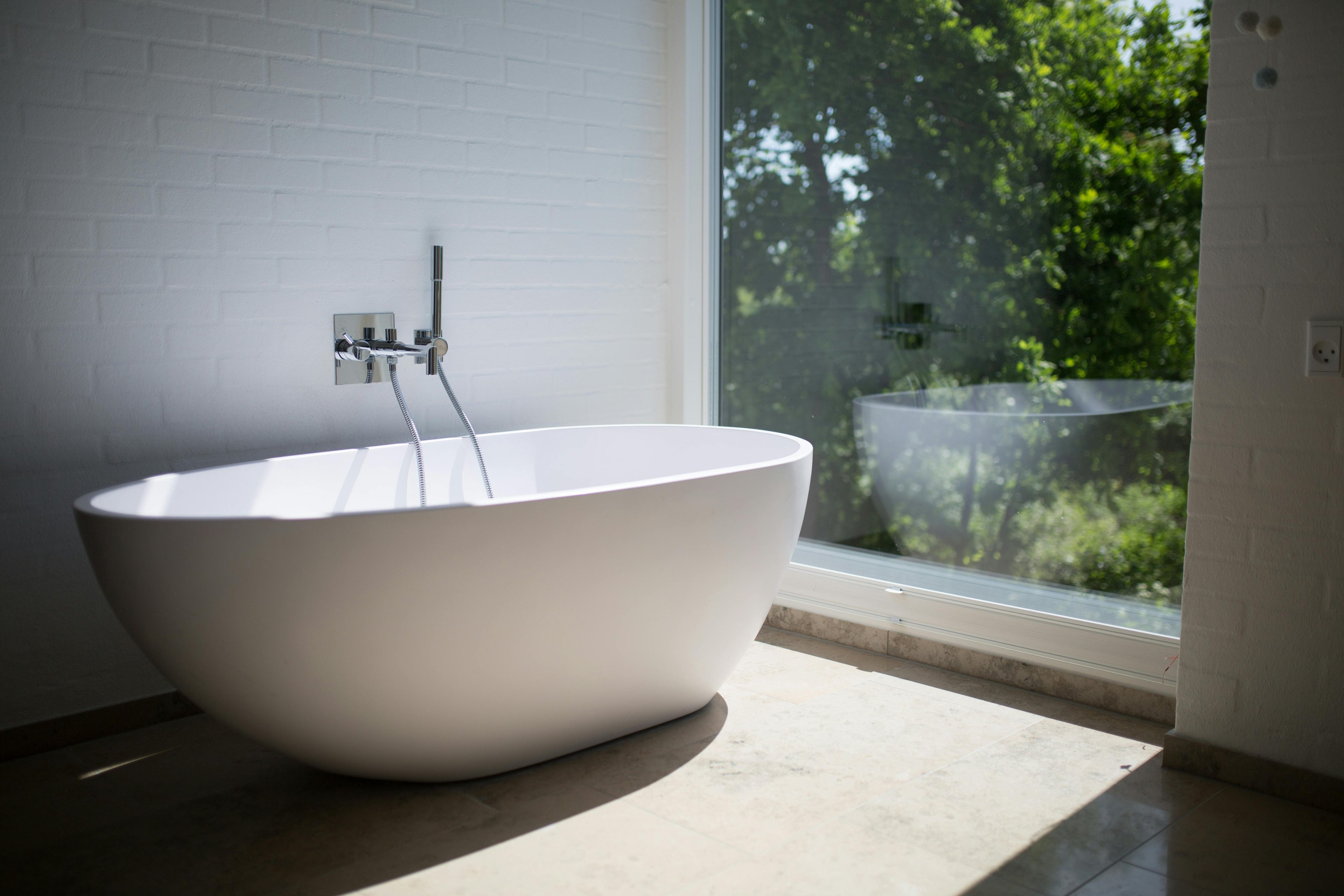 Bright bathroom featuring a white bathtub and large window by Timeless Bathrooms in Vale of Glamorgan – modern design with natural light